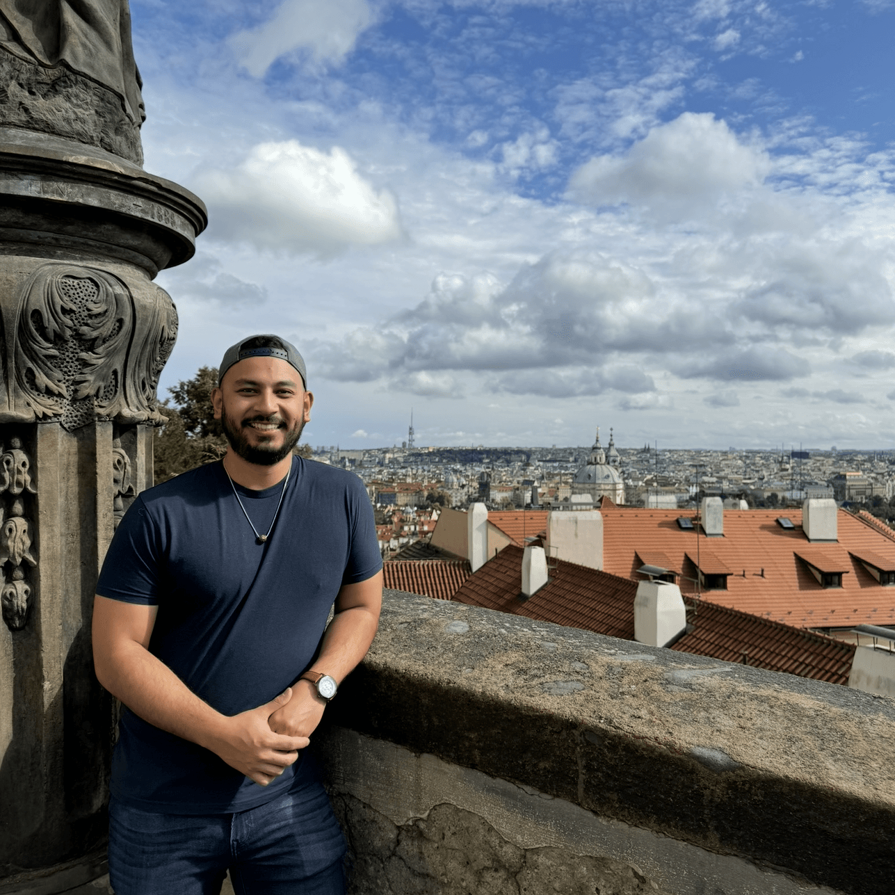 IMG_5470 a man standing on a ledge with a city in the background